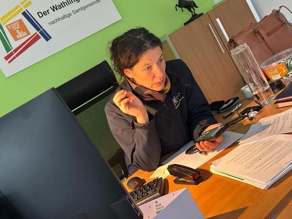 Samtgemeindebürgermeisterin Claudia Sommer telefoniert an ihrem Schreibtisch mit dem Krisenstab.