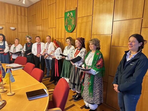 Ein ukrainischer Chor in farbenfrohen Landestrachten stehen im holzgetäfelten Ratssaal unter dem Wappen der Samtgemeinde Wathlingen.