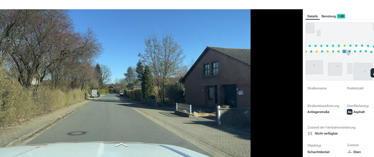 Blick auf eine Stra&szlig;e, links und rechts stehen B&auml;ume und rechts steht noch ein Haus.