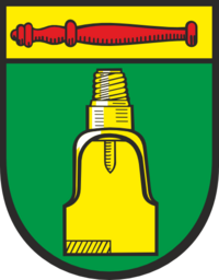 Bild vergrößern: Wappen der Gemeinde Nienhagen. Unterer Teil in dunkelgrün, oben ein breiter gelber Streifen mit einem roten Stab, im dunkelgrünen Bereich ist ein gelber Ölbohrkopf.
